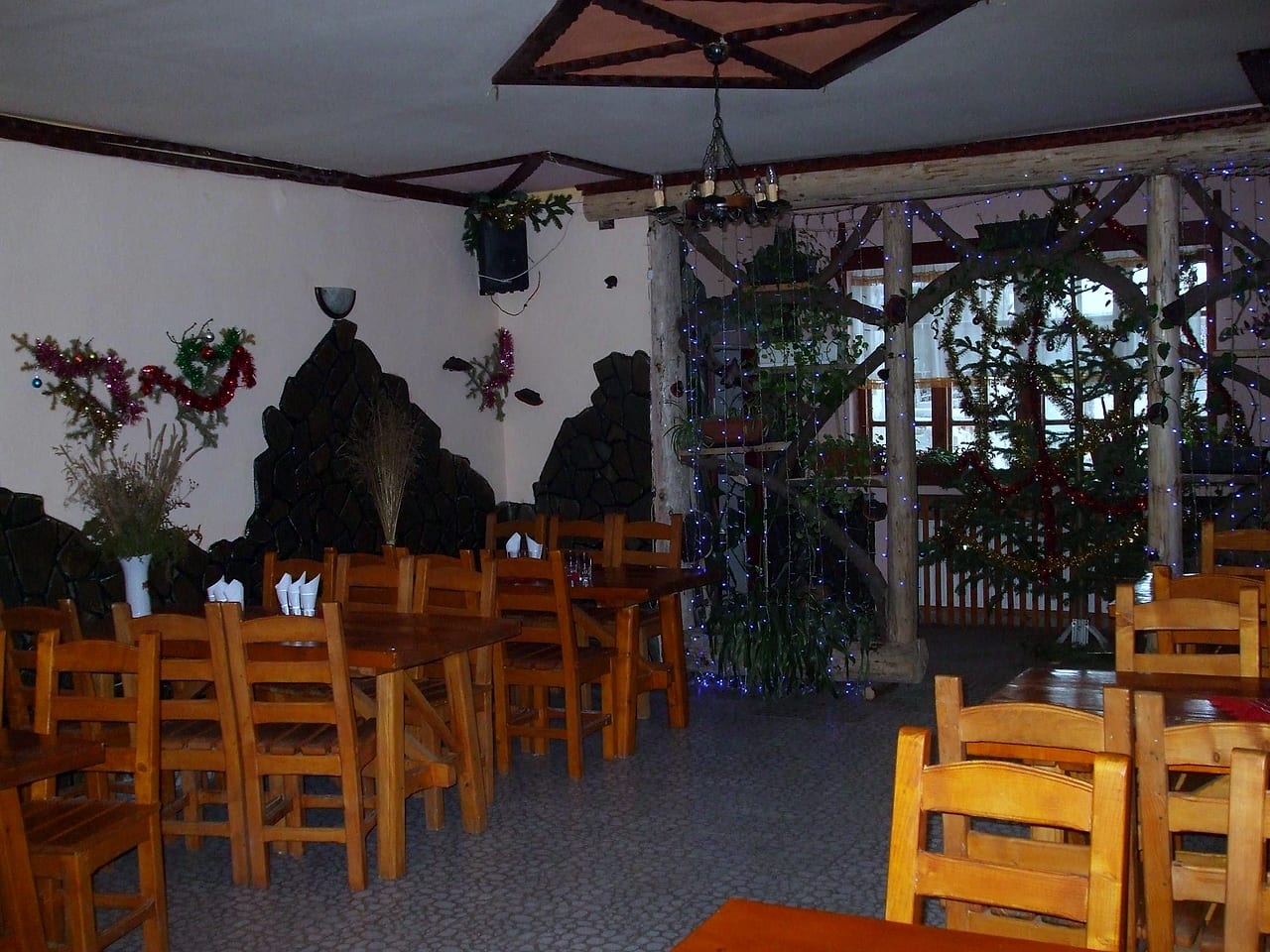 Sala mare văzută în unghi larg, cu legătura spre a doua încăpere și decorațiile de sărbători.